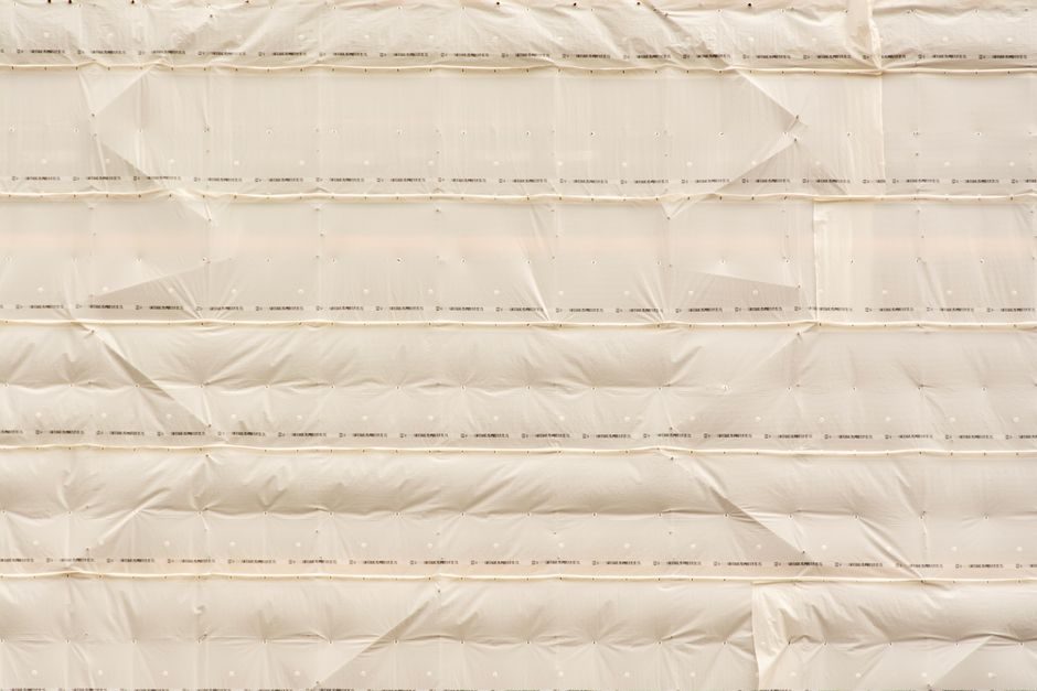 Textured beige cloth arrangement with pleats and folds, ideal for design backgrounds.